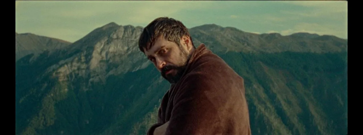 With Blessings On Your Way — a close portrait of the traveller against a mountain backdrop.